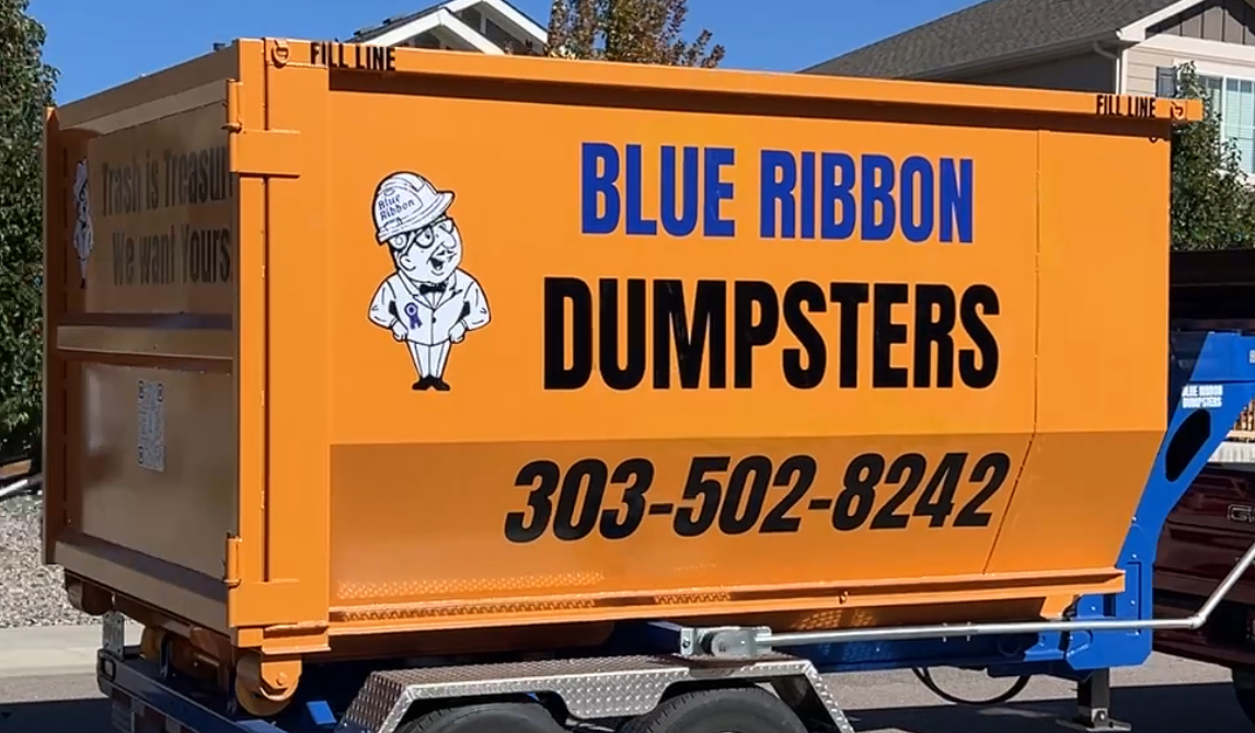 Blue Ribbon Dumpsters branded roll-off container in Denver driveway